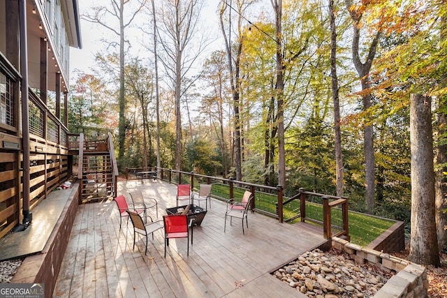 wooden deck with a fire pit and stairway