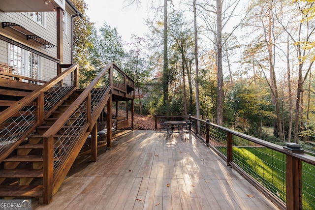 deck with outdoor dining space and stairway