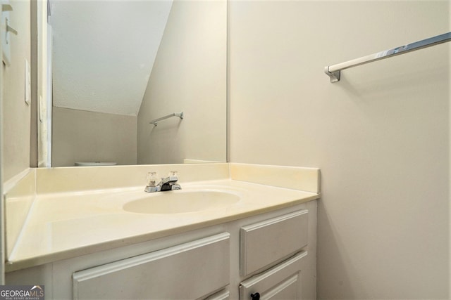 bathroom featuring vaulted ceiling and vanity