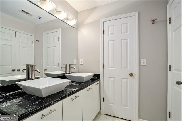 full bath with visible vents, a sink, and double vanity