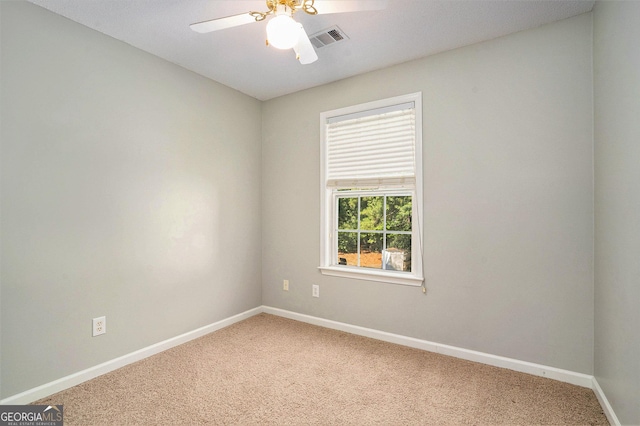 carpeted spare room with ceiling fan, visible vents, and baseboards