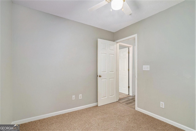 unfurnished room featuring light carpet, ceiling fan, and baseboards