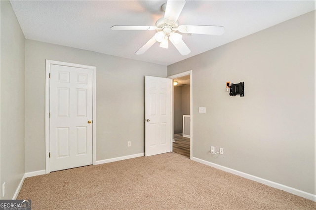 unfurnished bedroom featuring ceiling fan, baseboards, and carpet flooring