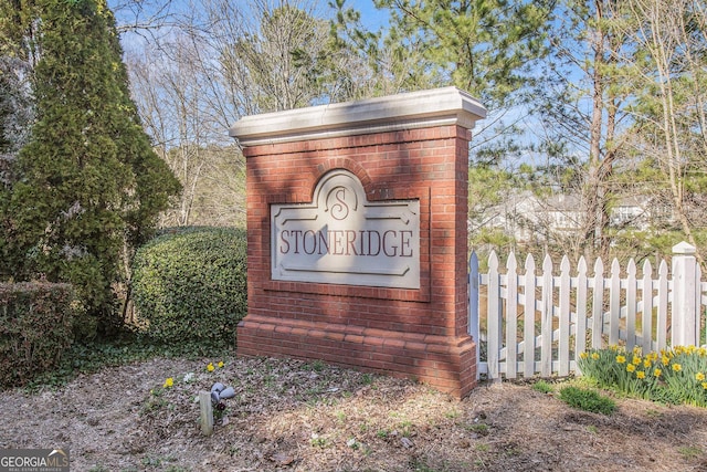 community / neighborhood sign featuring fence