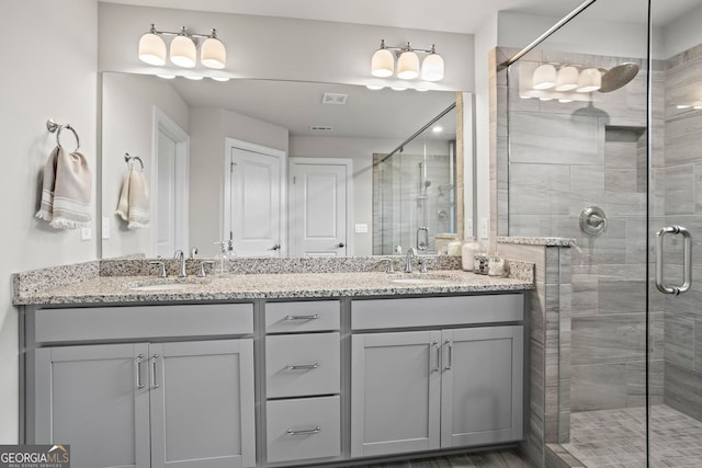 bathroom with double vanity, a sink, and a shower stall