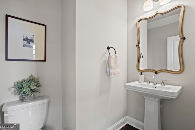 bathroom featuring toilet and baseboards