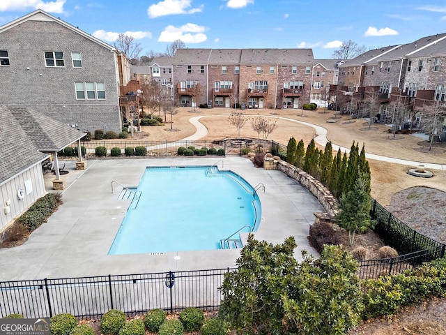 community pool featuring a residential view and fence