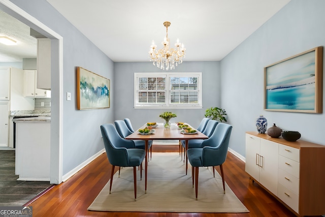 dining area with baseboards, an inviting chandelier, and dark wood finished floors