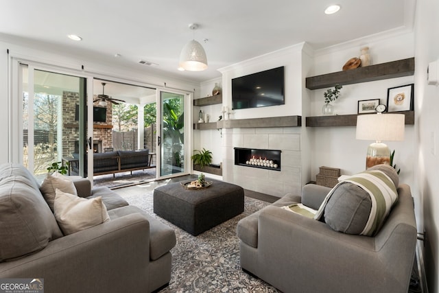 living area with recessed lighting, visible vents, crown molding, and a tiled fireplace