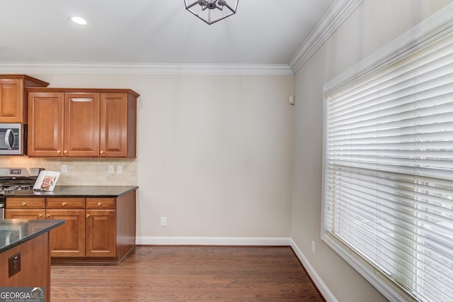 2275 W Village Ln SE, Smyrna, GA 30080 - kitchen featuring brown cabinets, dark stone countertops, stainless steel appliances, wood finished floors, and tasteful backsplash