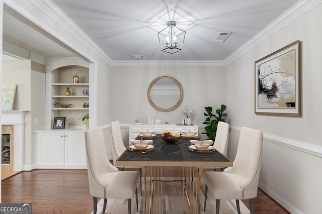 2275 W Village Ln SE, Smyrna, GA 30080 - dining area featuring visible vents, crown molding, wood finished floors, built in shelves, and a notable chandelier