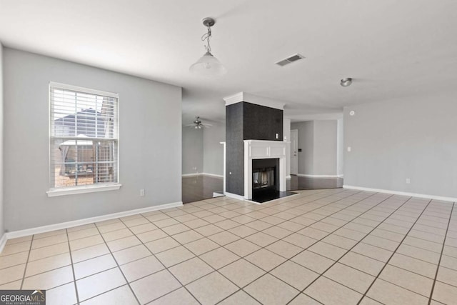 unfurnished living room with light tile patterned floors, baseboards, visible vents, a ceiling fan, and a fireplace