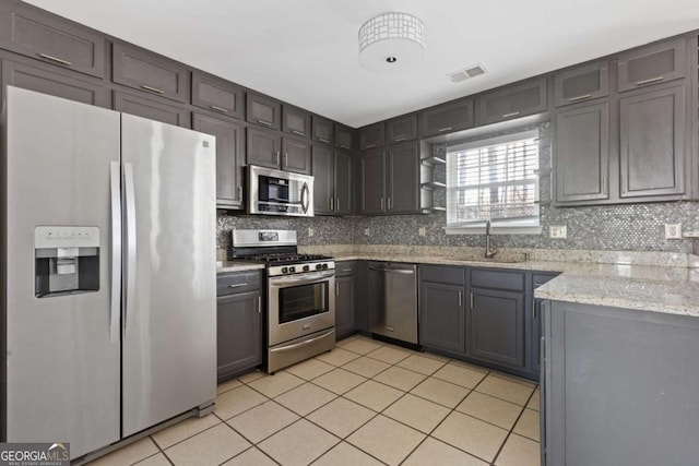 kitchen with stainless steel appliances, tasteful backsplash, visible vents, light tile patterned flooring, and a sink