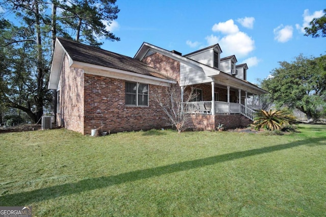 view of front of property with central AC unit, brick siding, a porch, and a front yard