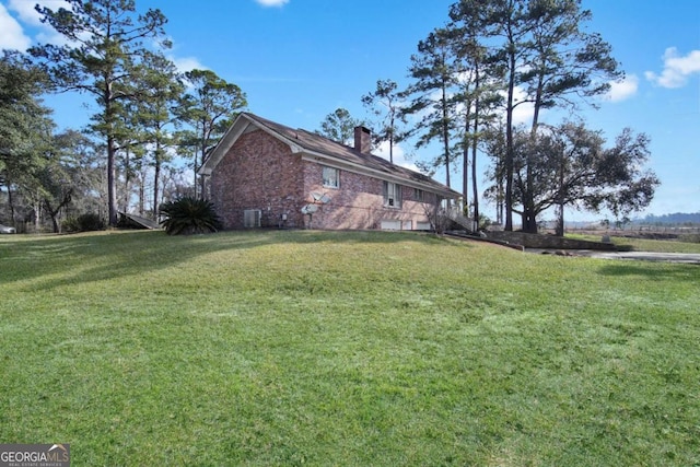 view of property exterior with brick siding, a yard, and a chimney