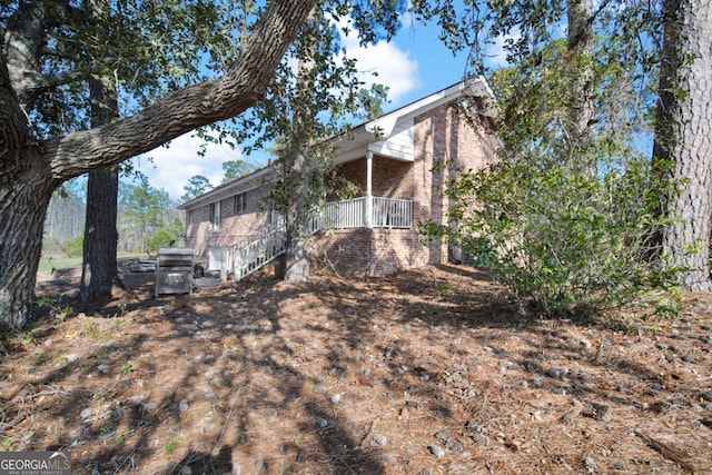 view of home's exterior featuring brick siding and a porch