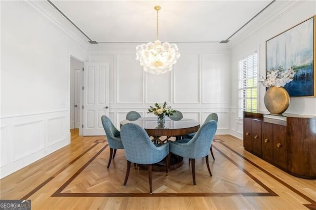 dining area featuring crown molding, a decorative wall, and a notable chandelier