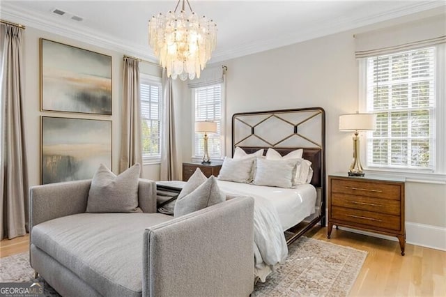 bedroom with visible vents, baseboards, ornamental molding, an inviting chandelier, and light wood-type flooring