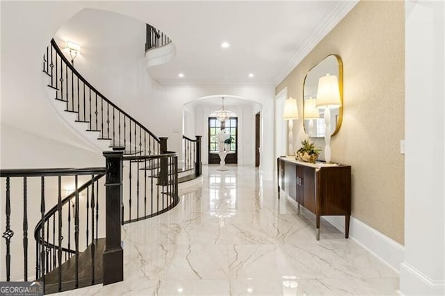 foyer entrance featuring arched walkways, recessed lighting, baseboards, marble finish floor, and crown molding