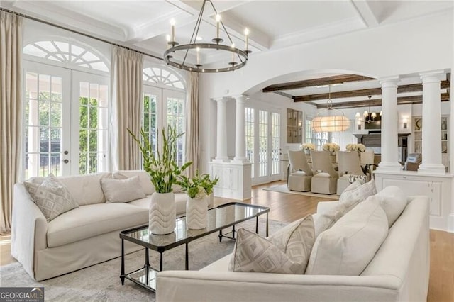 sunroom with arched walkways, french doors, a healthy amount of sunlight, and ornate columns