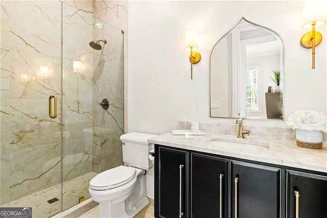 bathroom featuring toilet, a marble finish shower, and vanity