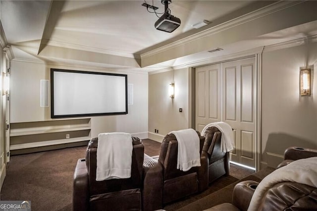 cinema room featuring dark colored carpet, ornamental molding, a raised ceiling, and baseboards