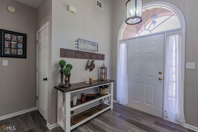 foyer entrance featuring dark wood-type flooring, visible vents, and baseboards