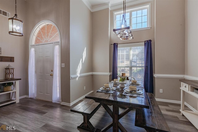 entryway featuring a high ceiling, visible vents, a notable chandelier, and wood finished floors