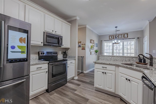 kitchen featuring stainless steel appliances, ornamental molding, white cabinetry, a sink, and light wood-type flooring