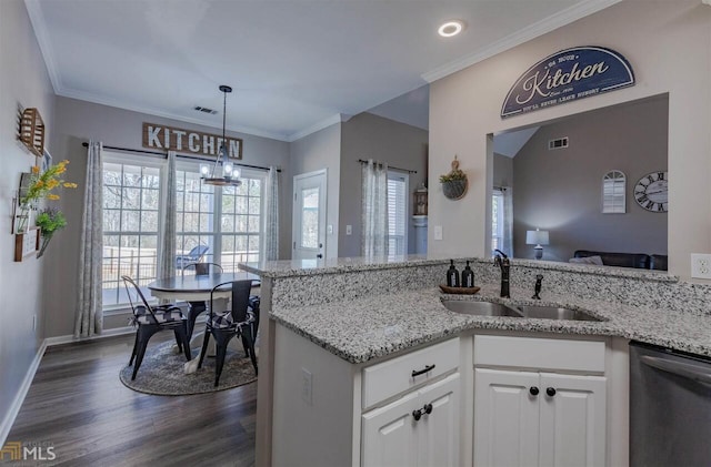 kitchen with light stone counters, dark wood-style flooring, visible vents, a sink, and dishwasher