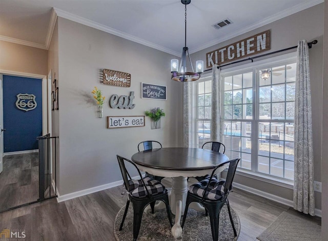 dining room with visible vents, crown molding, and wood finished floors