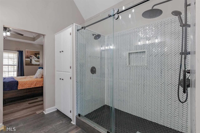 bathroom featuring a ceiling fan, a stall shower, connected bathroom, and wood finished floors