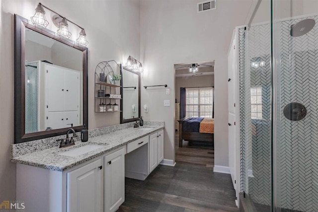 bathroom with visible vents, a sink, and a shower stall