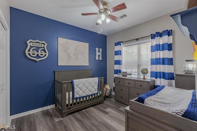 bedroom with baseboards, visible vents, ceiling fan, and wood finished floors