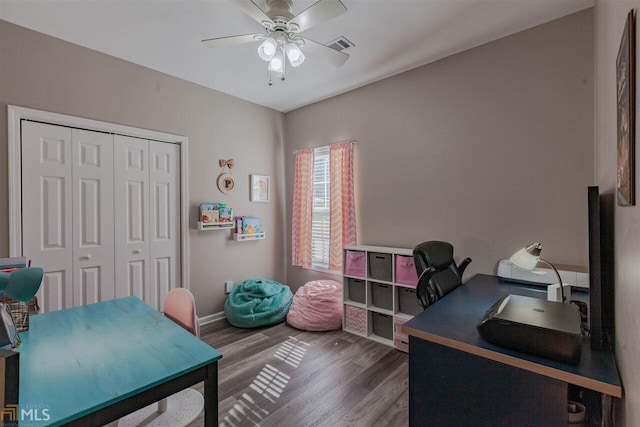 office area with baseboards, visible vents, a ceiling fan, and wood finished floors