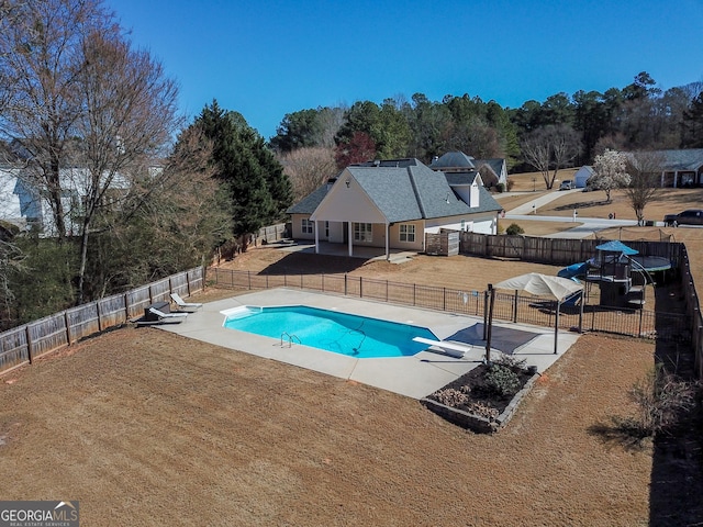 view of pool with a lawn, a fenced in pool, a patio, a fenced backyard, and a diving board