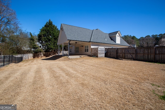 back of property featuring a patio area, a fenced backyard, a lawn, and a ceiling fan