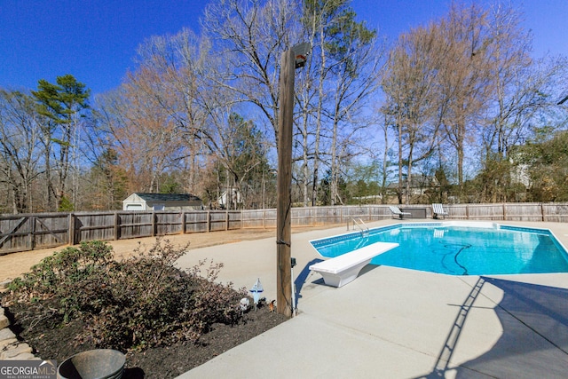 view of swimming pool with a diving board, a patio, a fenced backyard, and a fenced in pool