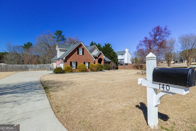 view of front of home featuring fence and brick siding