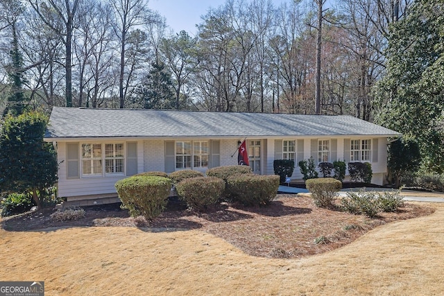 single story home with a shingled roof and brick siding