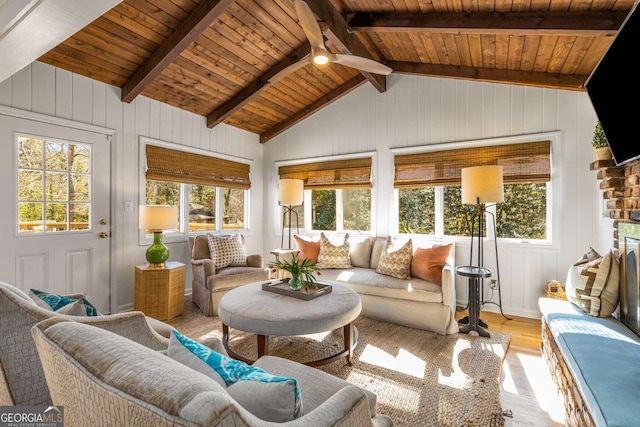 sunroom / solarium with vaulted ceiling with beams, wooden ceiling, and a ceiling fan