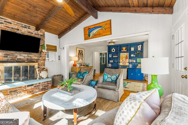 living room featuring vaulted ceiling with beams, wooden ceiling, a fireplace, and wood finished floors