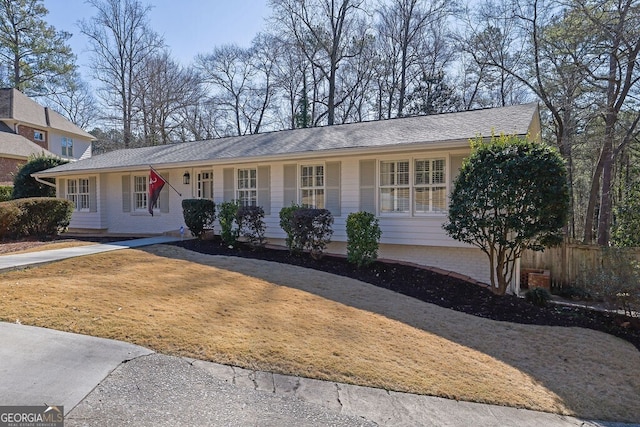 ranch-style house featuring a front lawn and fence