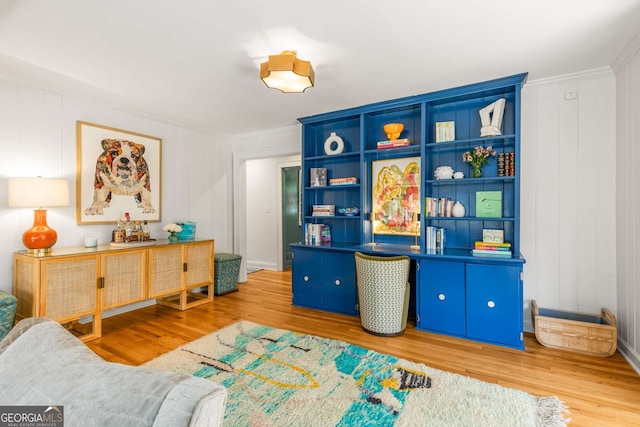 living area with crown molding and wood finished floors