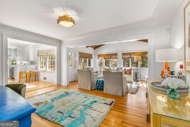 living area with crown molding and light wood-style flooring