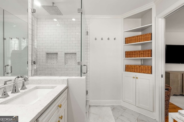 bathroom featuring marble finish floor, a shower stall, ornamental molding, and vanity