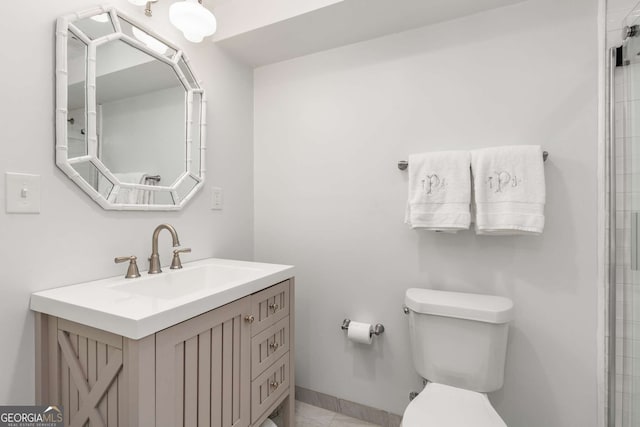 bathroom with baseboards, vanity, and toilet