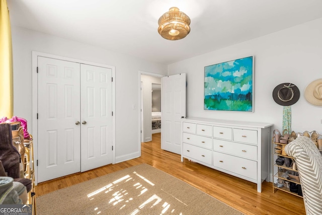 bedroom featuring baseboards, a closet, and light wood-style floors