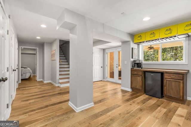 bar featuring stairs, light wood-style floors, recessed lighting, and refrigerator