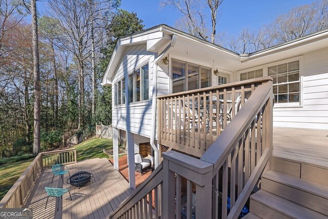 wooden terrace featuring an outdoor fire pit and stairway